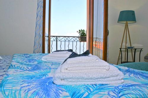 a bed with towels on it with a window at Piana delle Galee in Scilla