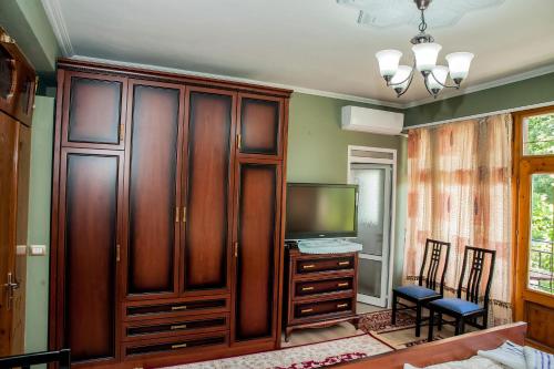 a bedroom with a tv and a wooden entertainment center at Villa Parku Rinia in Korçë