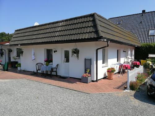 una casa bianca con patio arredato con tavolo e sedie di Zingster Ostseeklause a Zingst