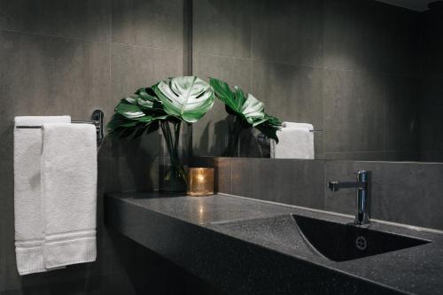 a bathroom with a sink and a vase with a flower at Stenungsbaden Yacht Club in Stenungsund