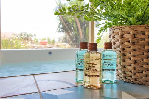 two bottles of alcohol sitting on a table next to a vase at Out of Africa Resort in Had Nes