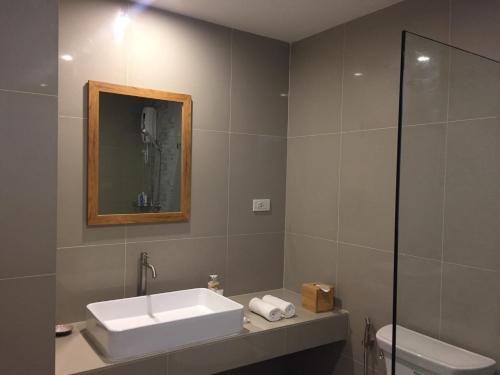 bagno con lavandino, specchio e servizi igienici di The Lake Udon a Udon Thani