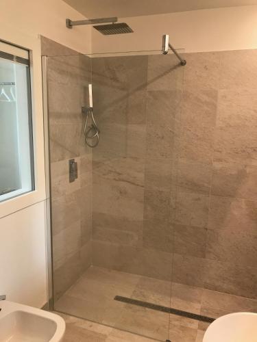 a shower with a glass door in a bathroom at Promenade Maison de Charme in Sanremo