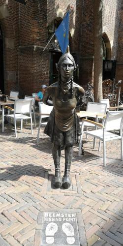 a statue of a boy standing in a courtyard at Bed & Breakfast Prins Hendrik (Zuidschermer) in Zuidschermer