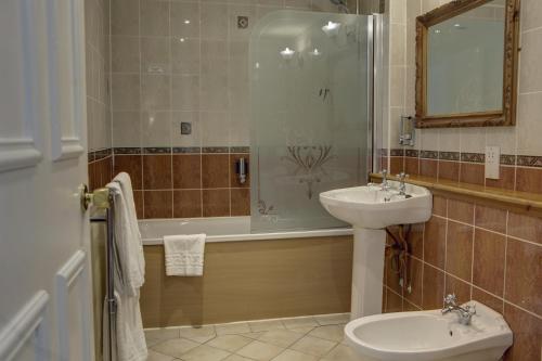 a bathroom with a sink and a toilet and a tub at Woodlands Hotel, BW Signature Collection in Dundee