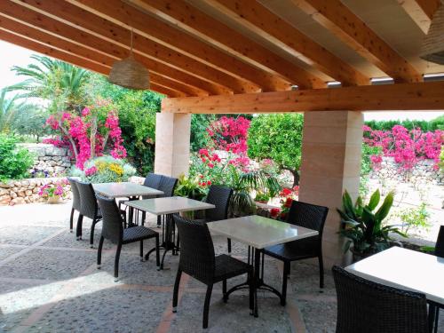 a patio with tables and chairs and pink flowers at son capellot in Felanitx