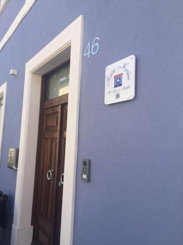 a blue building with a sign on the side of a door at Relais Marlene in Avezzano