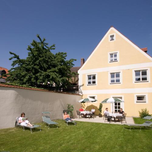 a group of people sitting in lawn chairs in front of a house at Hotel Zur Krone in Beilngries