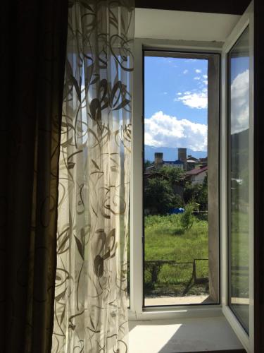 a window with a view of a field at Teona's Guesthouse in Mestia in Mestia