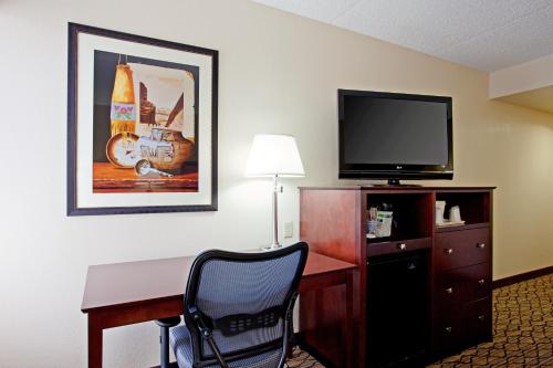 a hotel room with a desk and a flat screen tv at Holiday Inn Express Scottsdale North by IHG in Scottsdale