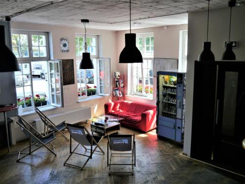 ein Wohnzimmer mit einem roten Sofa und Stühlen in der Unterkunft La Guitarra Hostel Gdańsk in Danzig