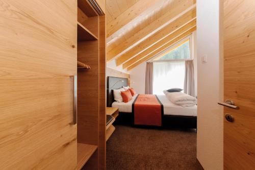 a small bedroom with a bed and a window at Sport Garni Kapplerhof – Ischgl/Kappl in Kappl