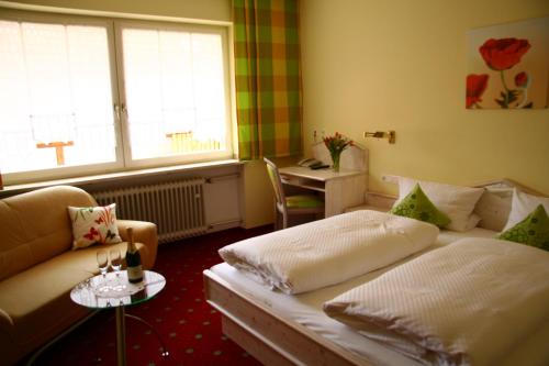 a room with two beds and a table and a window at Hotel Zur Krone in Beilngries
