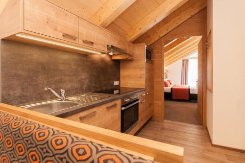 a kitchen with a sink and a stove at Sport Garni Kapplerhof – Ischgl/Kappl in Kappl