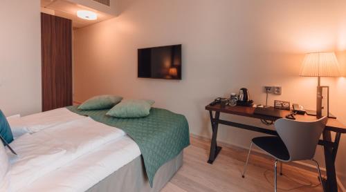 a hotel room with a bed and a desk at Clarion Hotel Helsinki in Helsinki