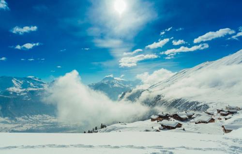 a mountain village in the snow with mountains in the background at Farfalla in Blatten bei Naters