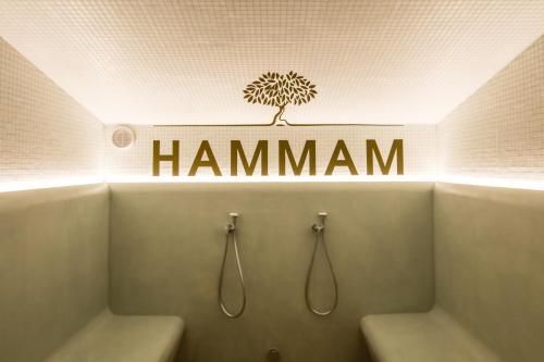 a bathroom with a sign that says hamann on the wall at Villa Duflot Hôtel & Spa Perpignan in Perpignan