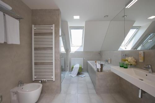 a bathroom with a sink and a toilet and a mirror at Hotel Panská Zahrada in Dobřichovice