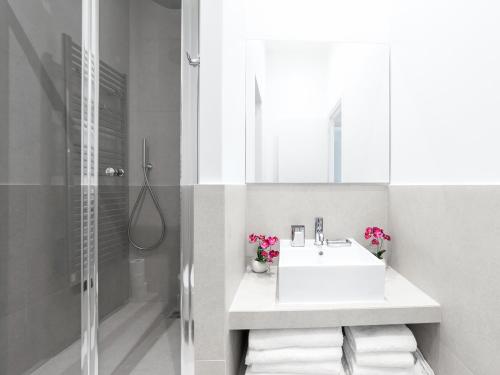 une salle de bain blanche avec un lavabo et une douche dans l'établissement LivinParis - Luxury 4 Bedrooms Opera I, à Paris