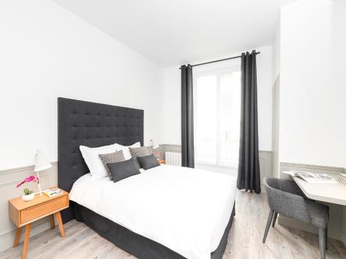 une chambre avec un grand lit et un bureau dans l'établissement LivinParis - Luxury 4 Bedrooms Opera I, à Paris