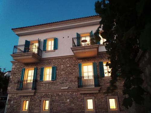 a tall building with windows and balconies on it at Çeşme Kale Taş Apart in Cesme
