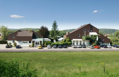 eine Gruppe von Häusern und Autos, die auf einem Parkplatz geparkt sind in der Unterkunft Hotel Angelo in Saarbrücken