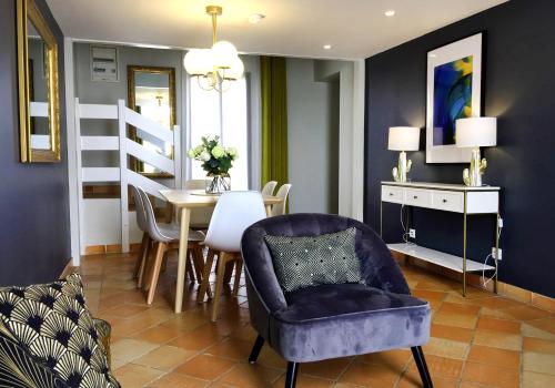 a living room with a purple chair and a table at Hotel Les Suites - Domaine de Crécy in Crecy la Chapelle