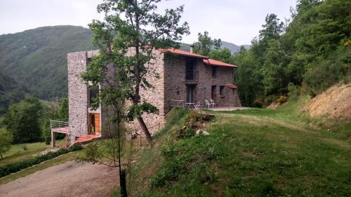 uma casa de pedra no lado de uma colina em Chambres d'hôtes Mas La Tardosse em Prats-de-Mollo-la-Preste