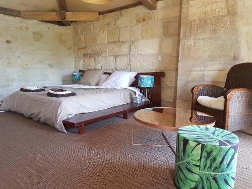 - une chambre avec un lit, une table et des chaises dans l'établissement La Ferme du Ciel, à Laruscade