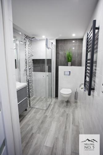 a bathroom with a shower and a toilet and a sink at Willowa NO. 5 APARTAMENTS in Wisła