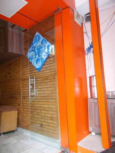 a shower in a kitchen with an orange wall at Premier rooms with Rooftop Terrace Restaurant in Nainital