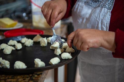 a person is preparing food on a pan with a spoon at Pousada UpSerra in Urubici