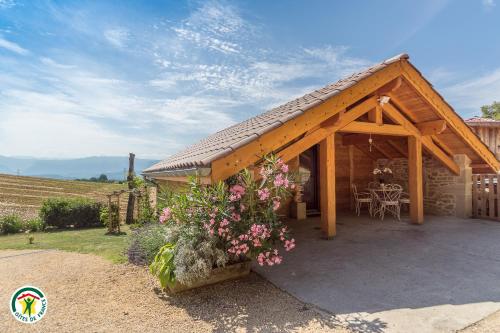 einen Holzpavillon mit einem Tisch und ein paar Blumen in der Unterkunft Chalet le Clos de l'Orme in Saint-Lattier