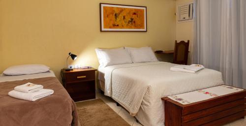 a hotel room with two beds with towels on them at Pousada UpSerra in Urubici