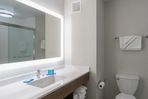 uma casa de banho com um lavatório, um espelho e um WC. em Holiday Inn Express Radcliff Fort Knox, an IHG Hotel em Radcliff