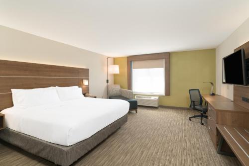 a hotel room with a bed and a flat screen tv at Holiday Inn Express Radcliff Fort Knox by IHG in Radcliff
