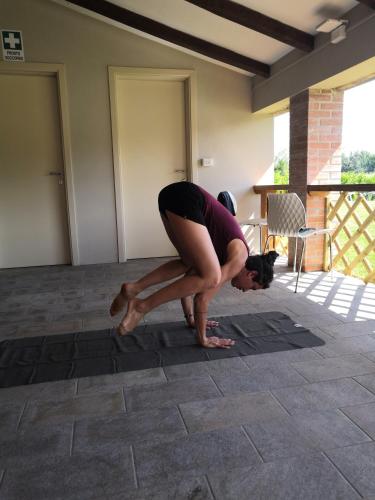 a woman doing a yoga pose on a tile floor at Tenuta San Giovanni Lucca in Lucca