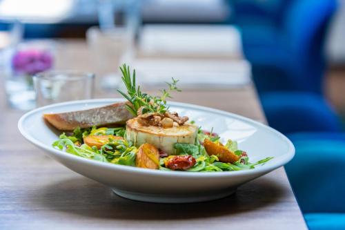 a white plate of food on a wooden table at Mercure Jelenia Góra in Jelenia Góra