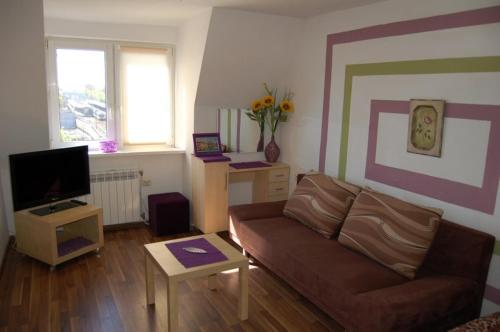 a living room with a couch and a tv at Małgorzata Pokoje in Sopot