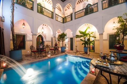 a swimming pool in a building with a large room at Riad Caesar in Marrakesh