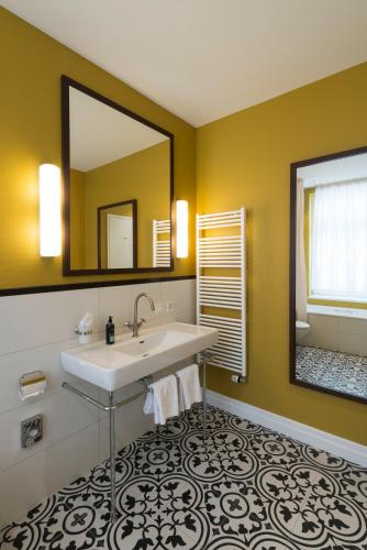 a bathroom with a sink and a mirror at Blue City Boutique Hotel in Baden