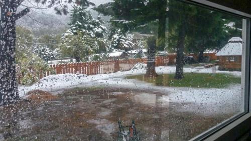 a view of a snow covered yard from a window at Mapunre in Malalcahuello