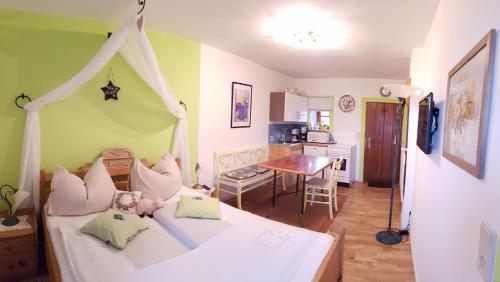 a bedroom with a bed and a kitchen with a table at FerienAppartments Landhaus FühlDichWohl in Fehring
