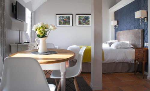 a hotel room with a table and a bed at Hotel Les Suites - Domaine de Crécy in Crecy la Chapelle