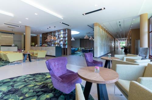 a lobby with purple chairs and tables at Mercure Jelenia Góra in Jelenia Góra