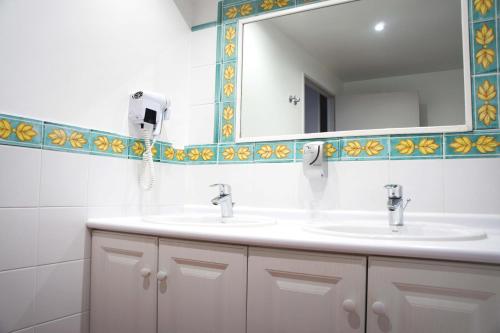a bathroom with two sinks and a mirror at Hotel Les Suites - Domaine de Crécy in Crecy la Chapelle