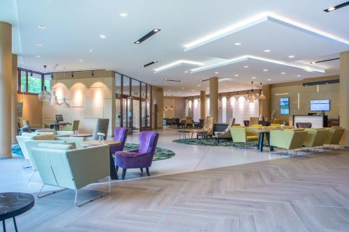 a lobby of a hotel with tables and chairs at Mercure Jelenia Góra in Jelenia Góra