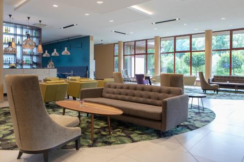 a lobby with a couch and tables and chairs at Mercure Jelenia Góra in Jelenia Góra