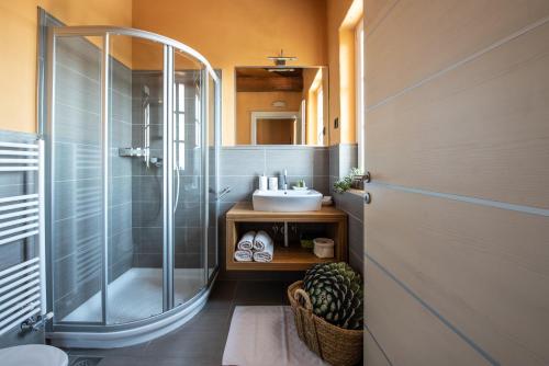 ein Bad mit einer Dusche und einem Waschbecken in der Unterkunft Klinec Plešivo Art Rooms in Dobrovo