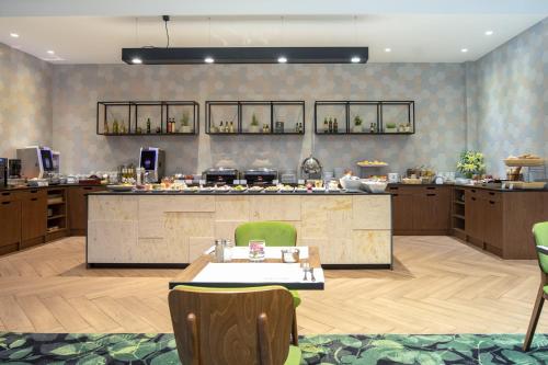 a large kitchen with a counter and a table at Mercure Jelenia Góra in Jelenia Góra